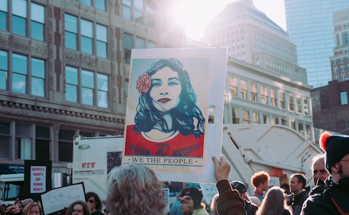 Person holding "we the people" sign at a women's march jan 2020